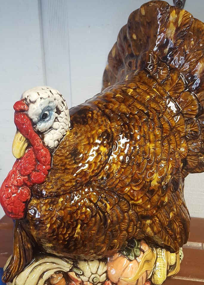 A statue of a turkey sitting on top of a pile of pumpkins.