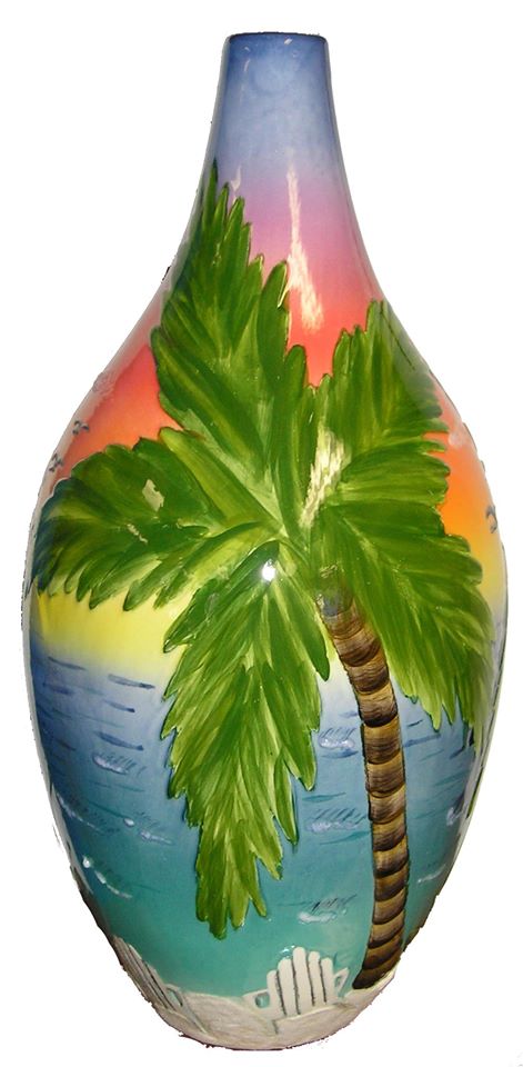 A colorful vase with a palm tree painted on it.