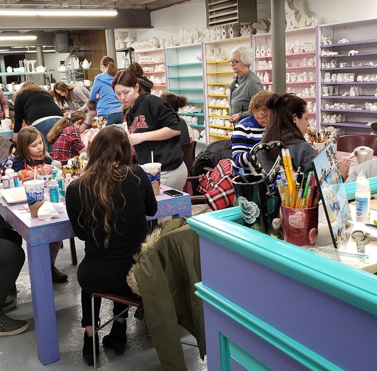 Three teddy bears sitting on top of a sign that says happy day