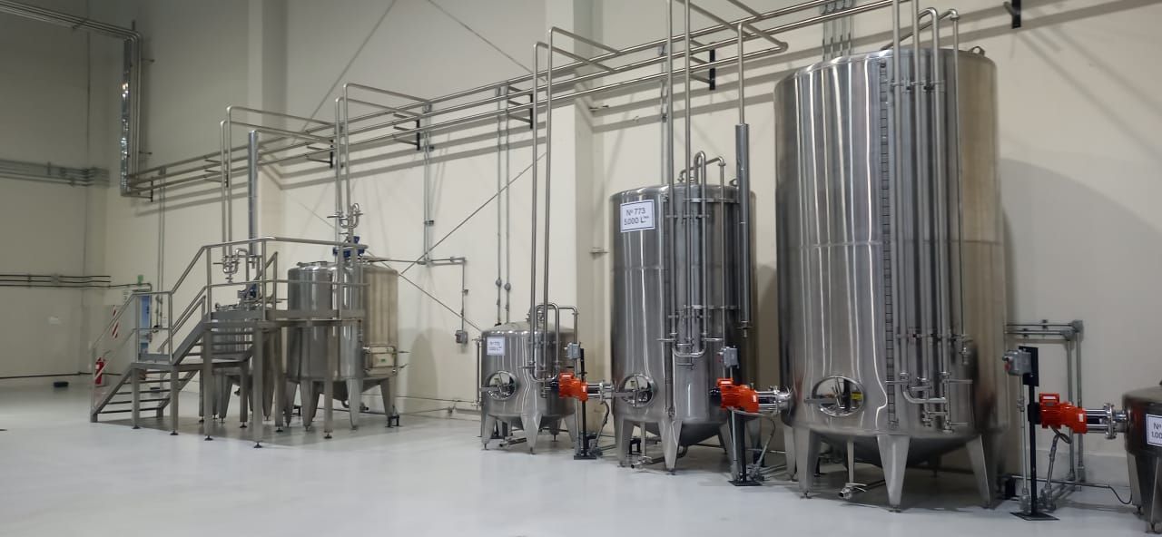 Tanques y tuberías industriales de acero inoxidable en un entorno industrial.