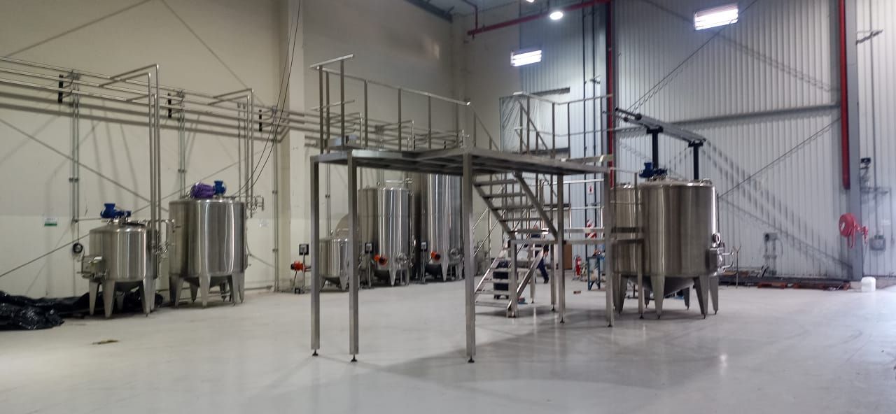 Tanques y plataforma de acero inoxidable en una gran instalación industrial.