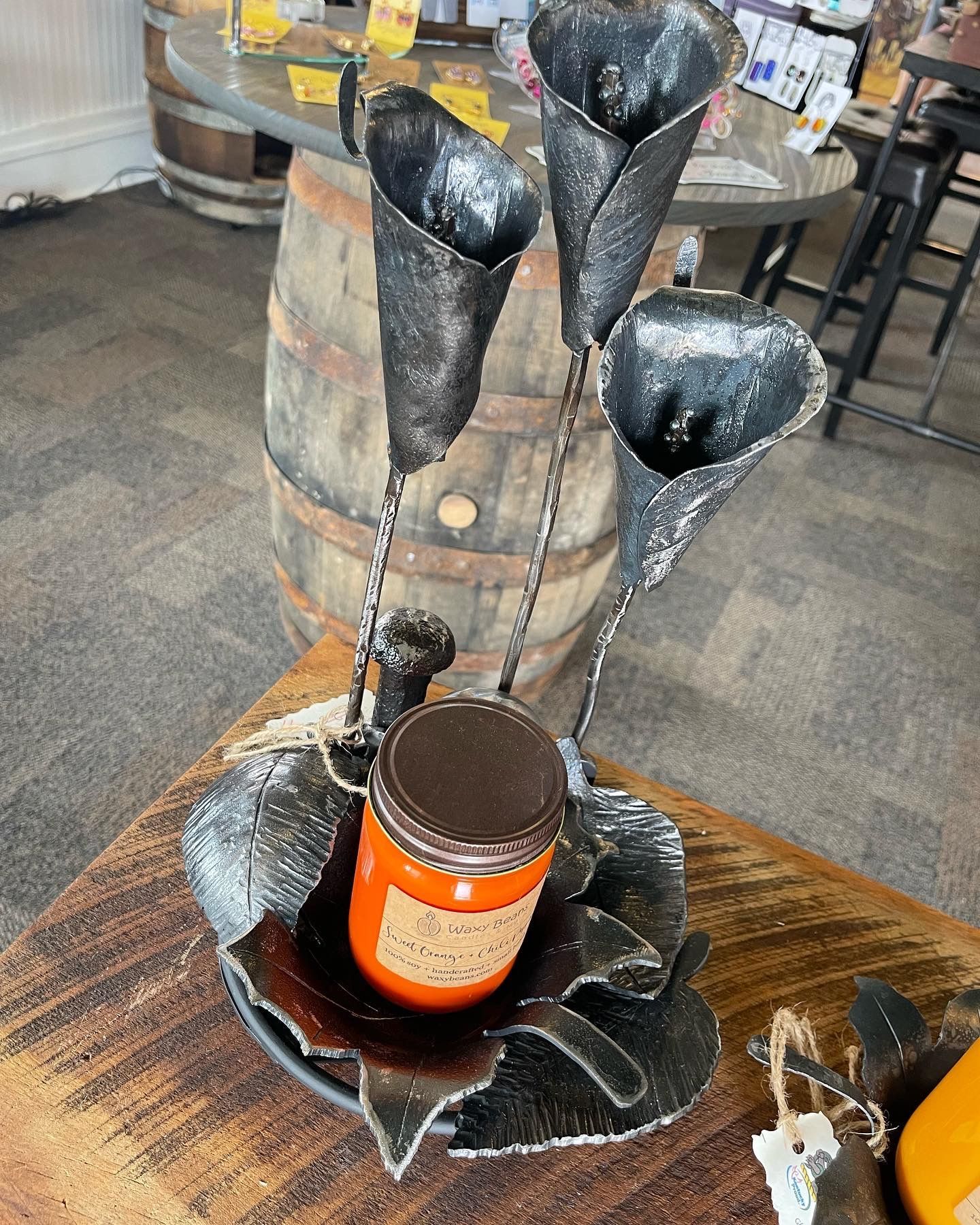 A candle is sitting on a table next to a barrel.