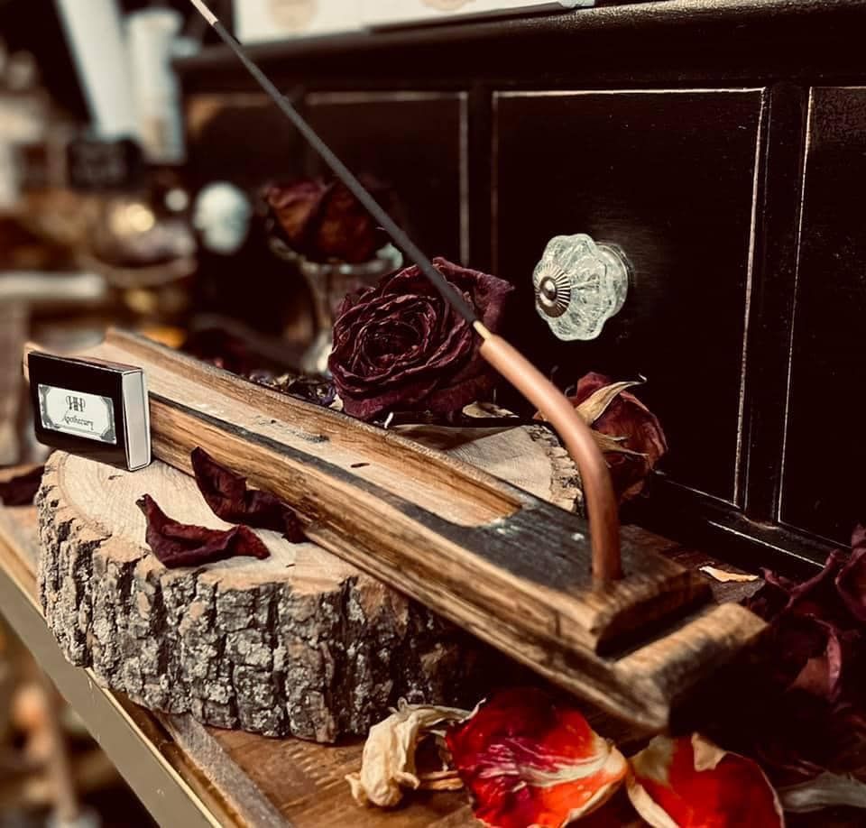 A wooden incense burner is sitting on a wooden table