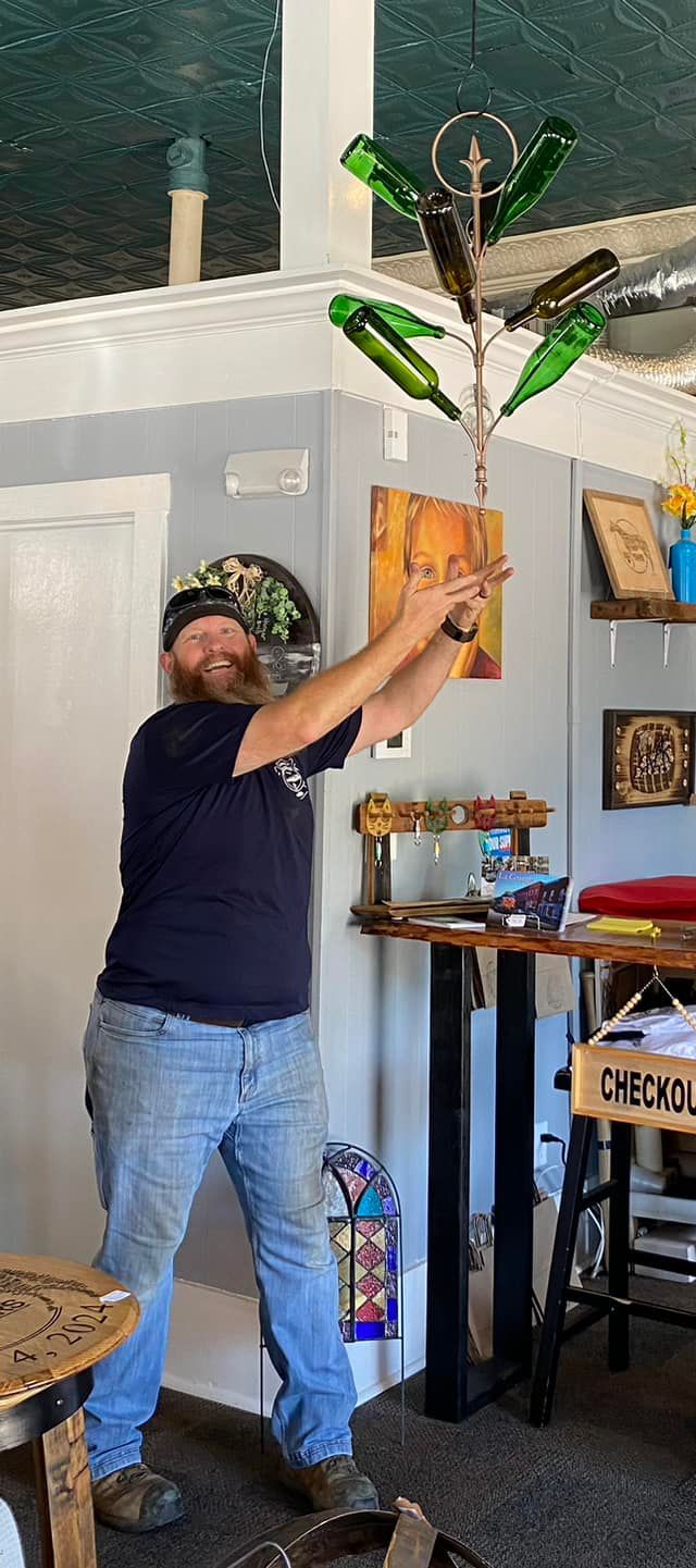 A man is standing in a room holding a bottle in his hand.