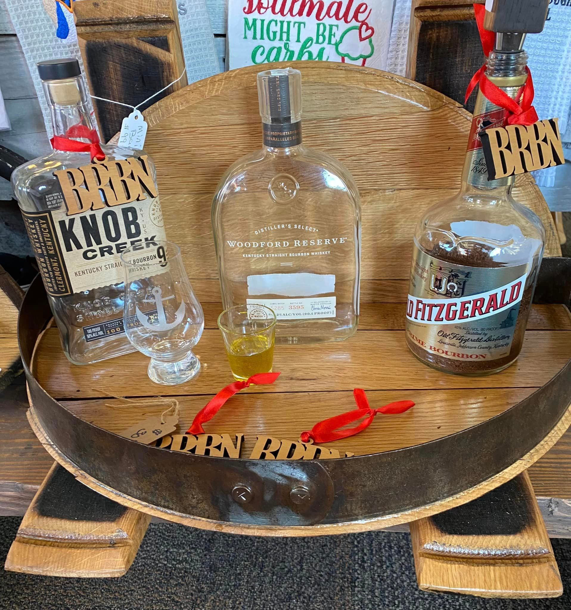 Three bottles of liquor are sitting on a wooden table.