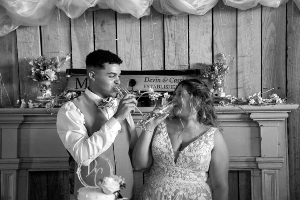 A bride and groom are drinking champagne at their wedding reception.