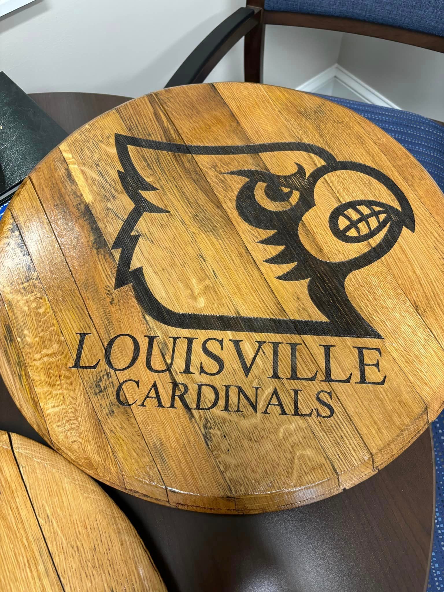 A wooden table with the louisville cardinals logo on it