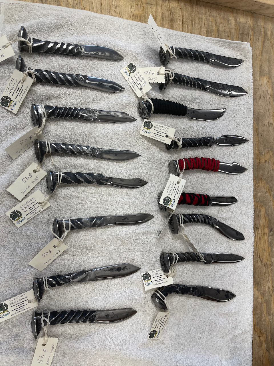 A bunch of knives made out of nails are sitting on a towel.