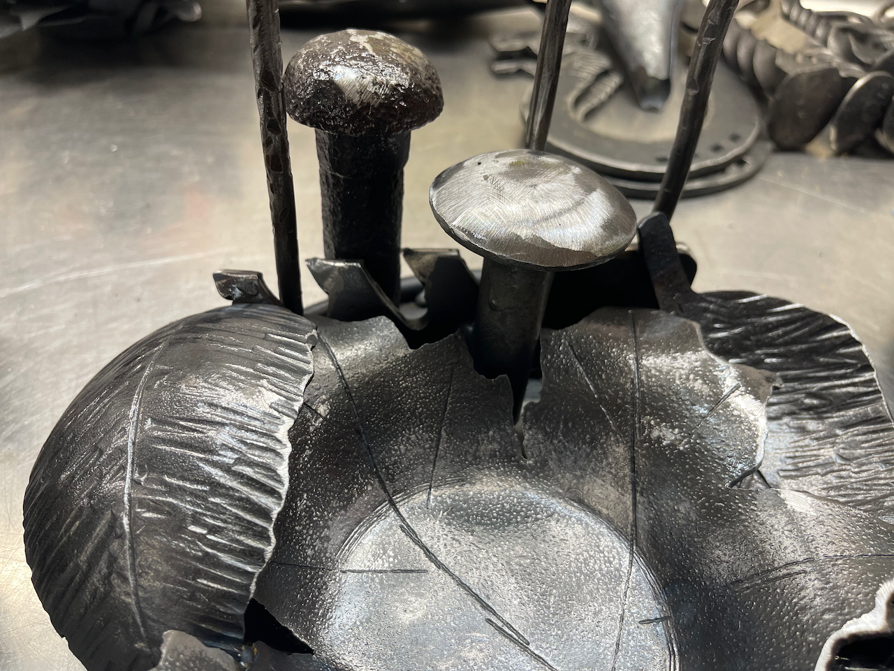A close up of a metal object with mushrooms on it