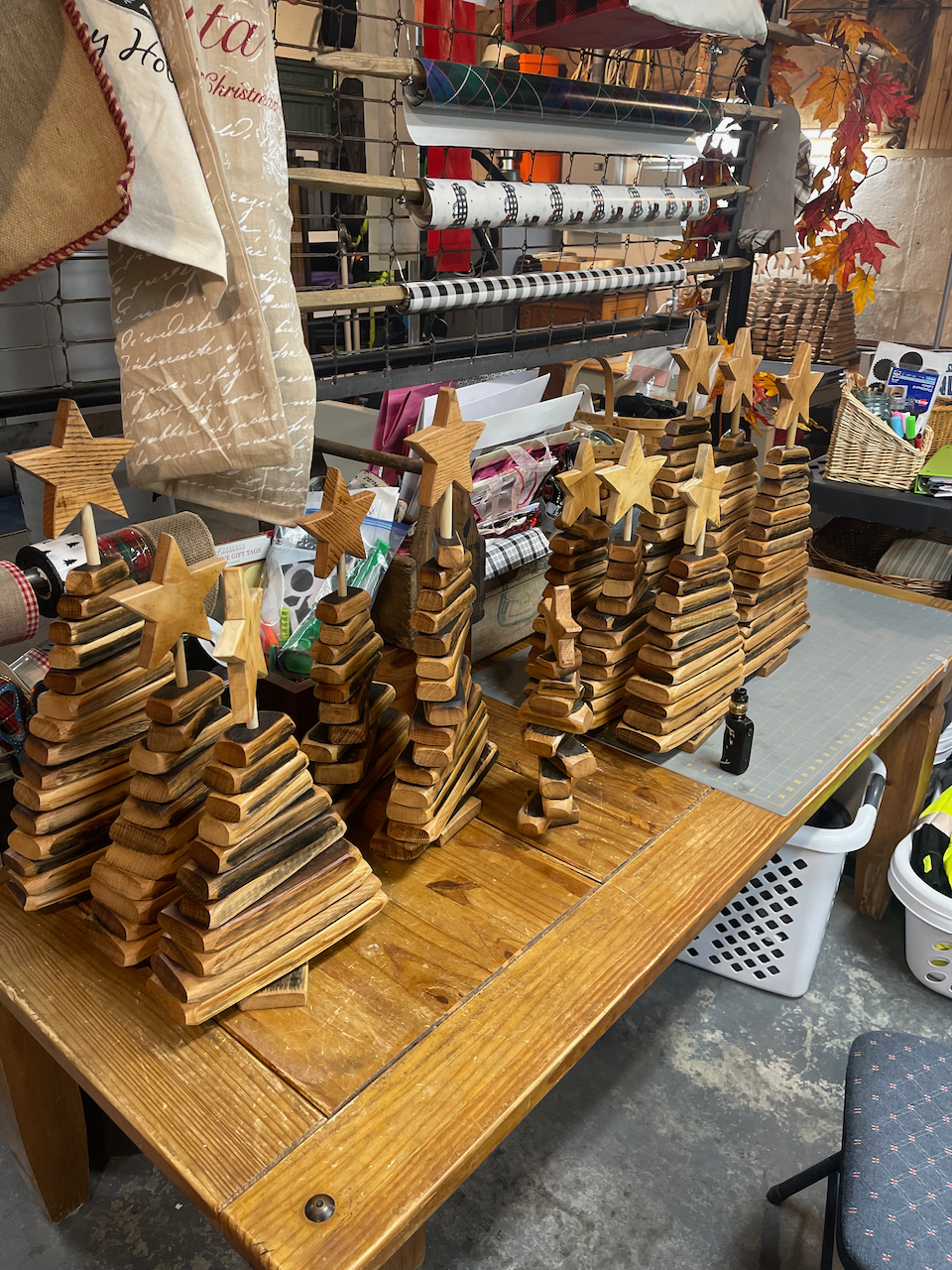 A table with a bunch of wooden christmas trees on it