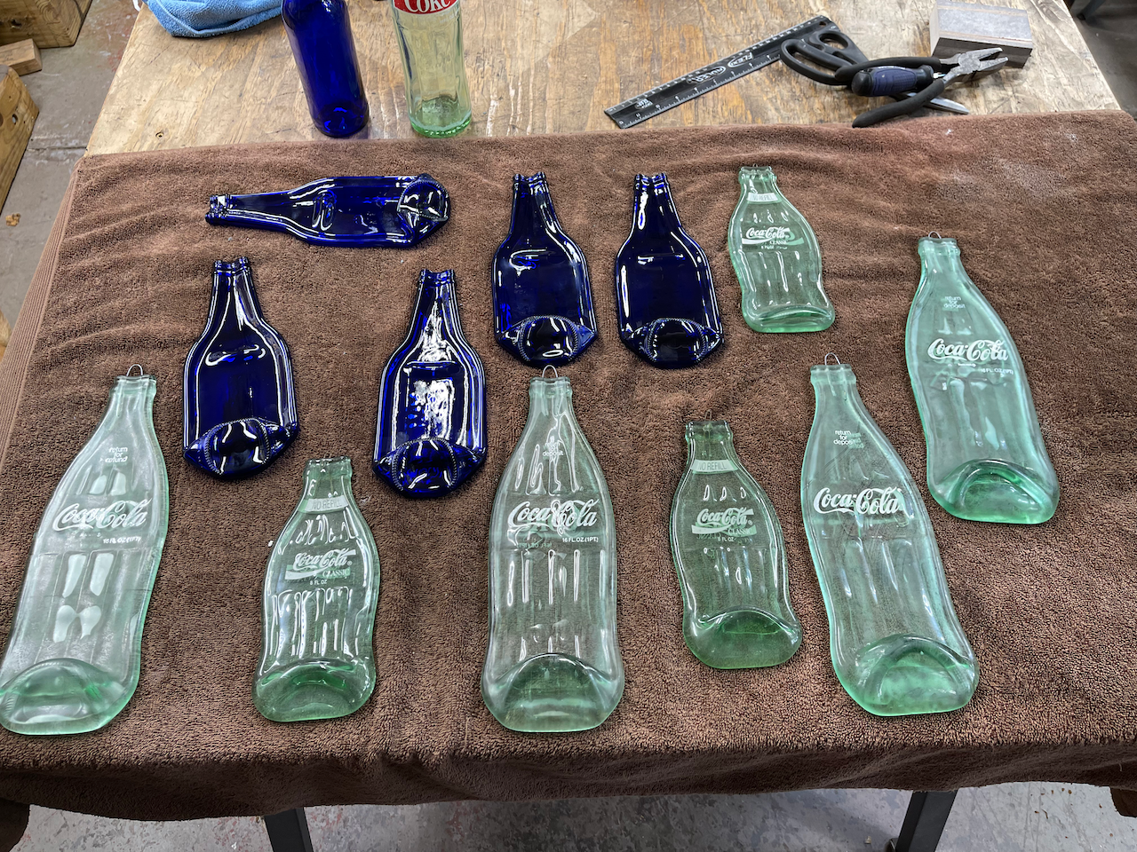 A bunch of empty coca cola bottles are sitting on a table.