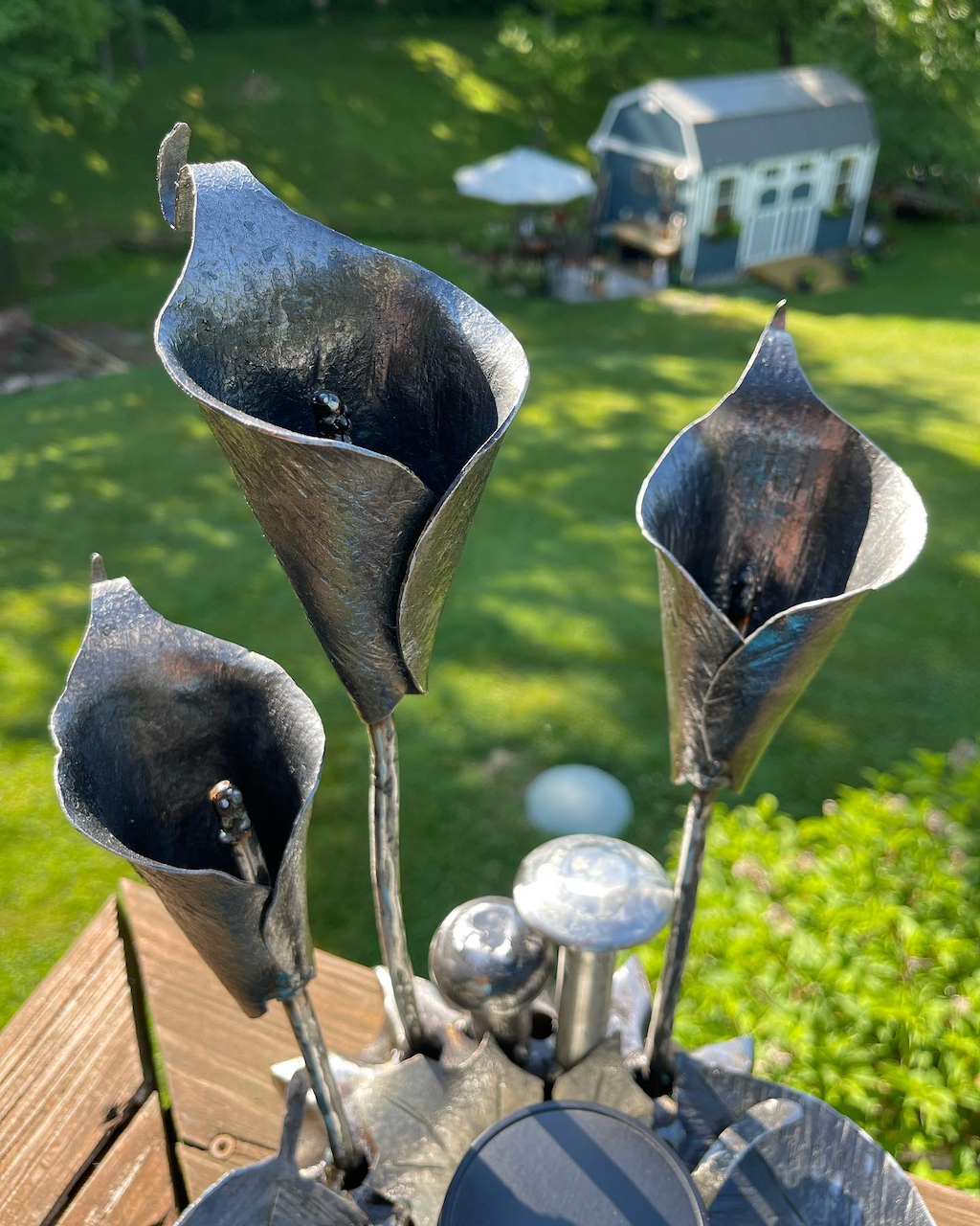 A bunch of metal flowers are sitting on top of a wooden table.