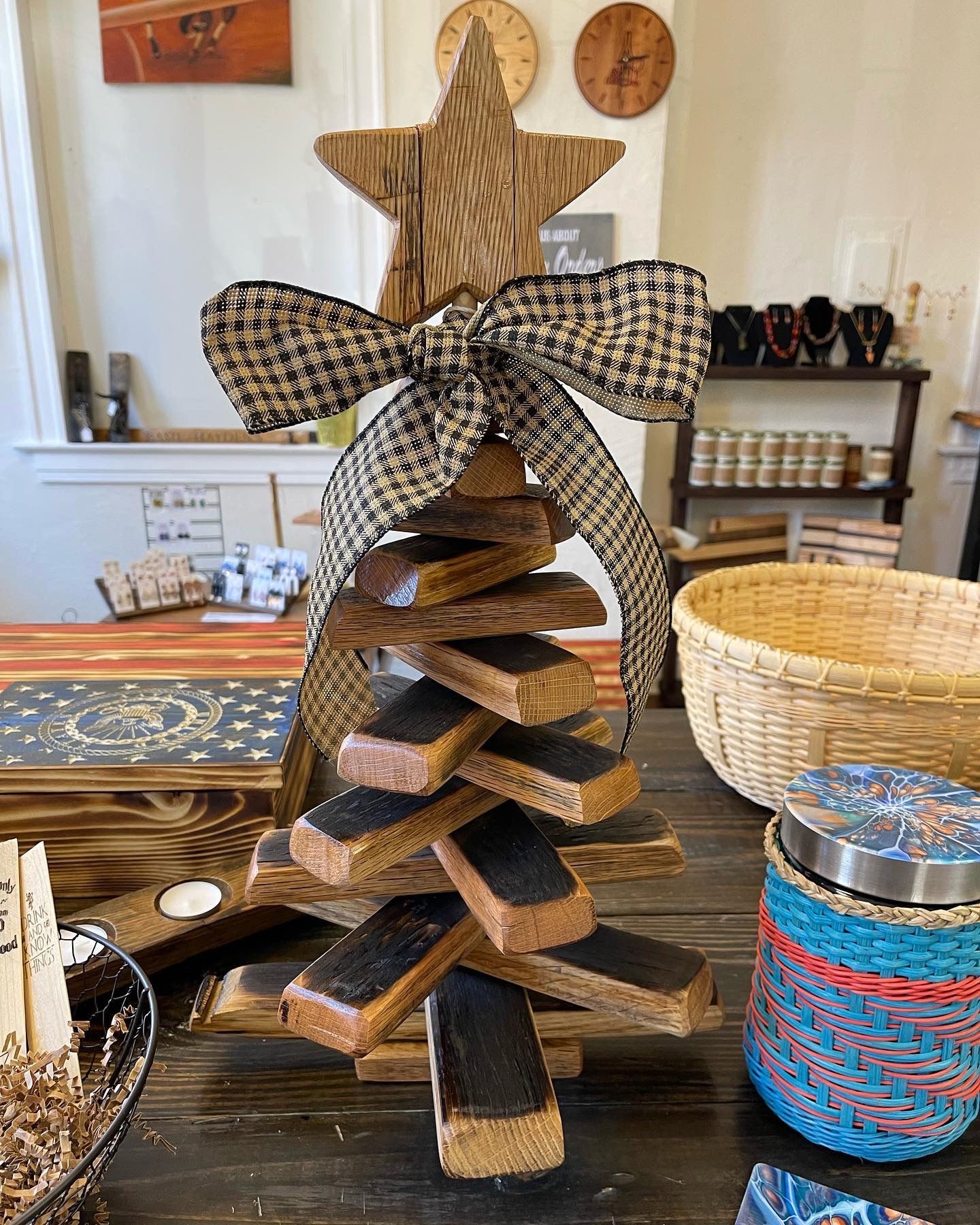 A wooden christmas tree with a star on top is sitting on a table.