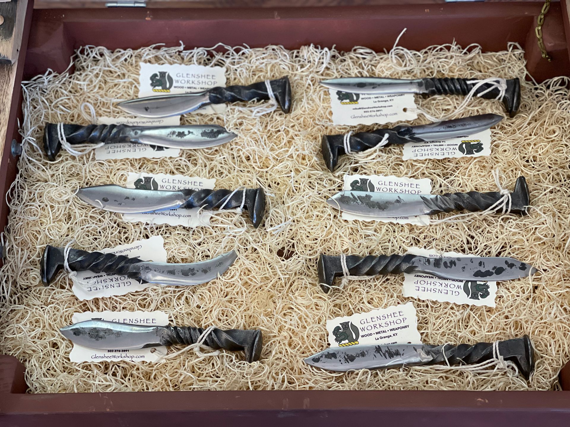 A bunch of knives are sitting on top of a pile of hay.