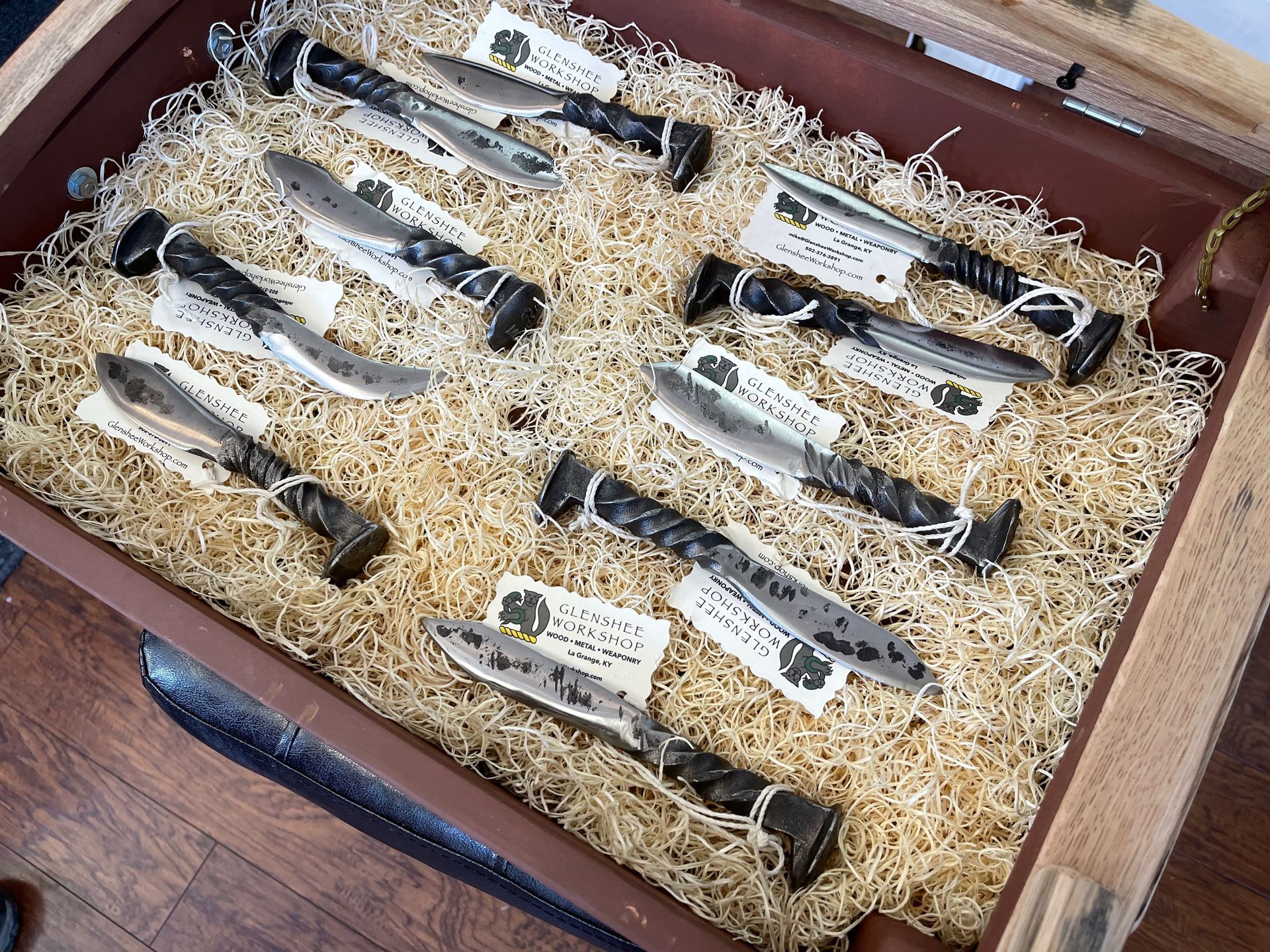 A bunch of knives are sitting on top of a pile of hay.
