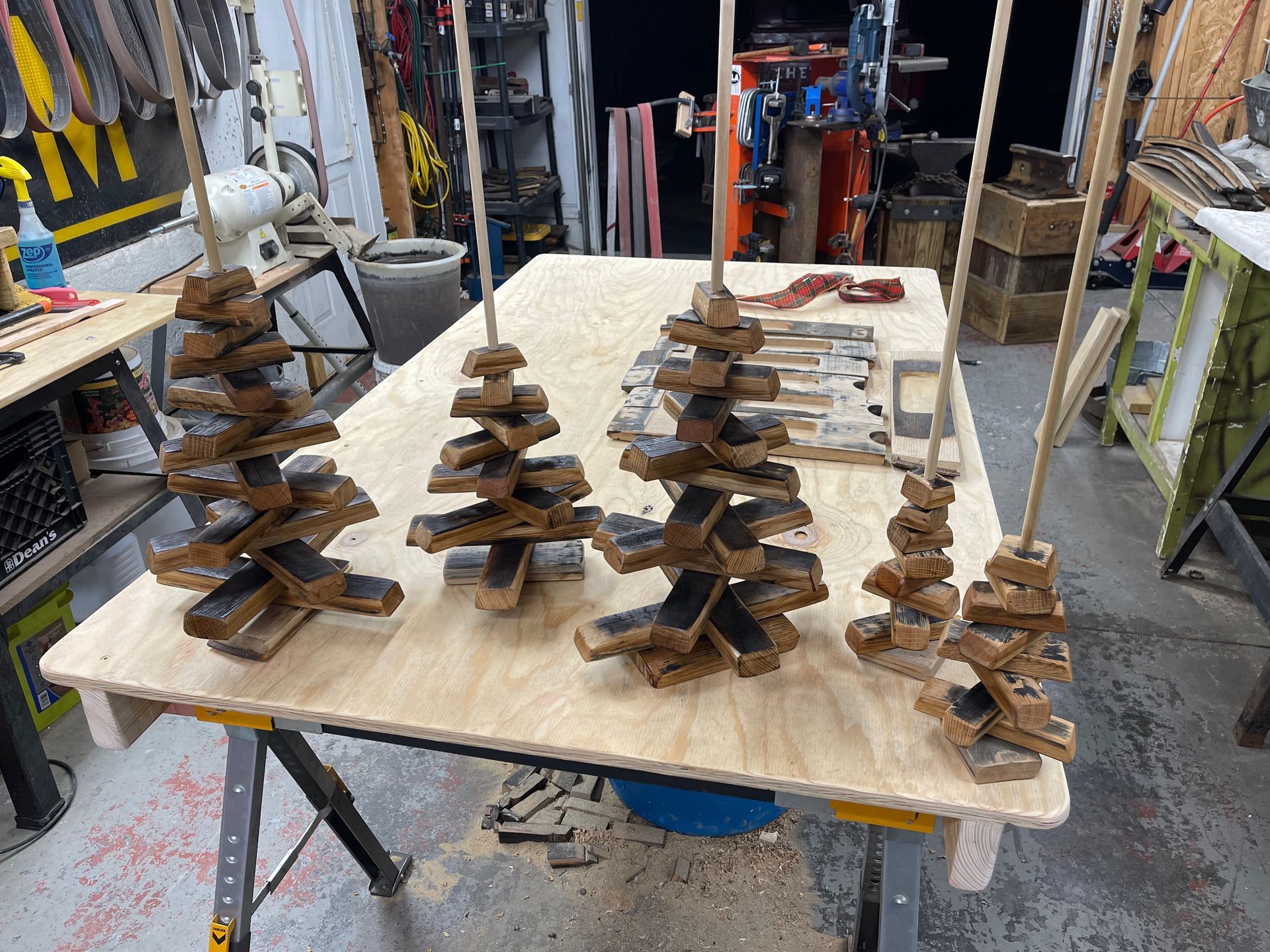 Three wooden christmas trees are sitting on top of a wooden table.
