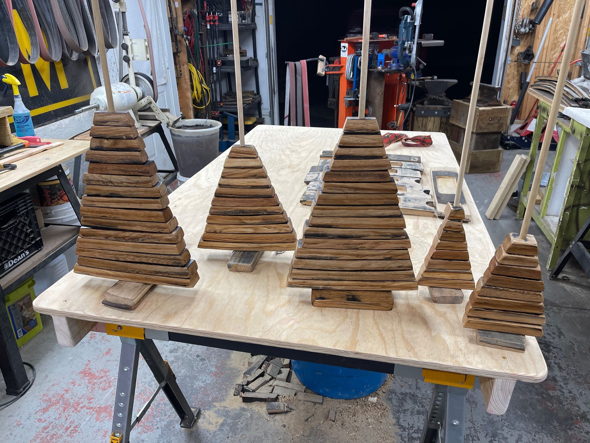 Four wooden christmas trees are sitting on a wooden table.