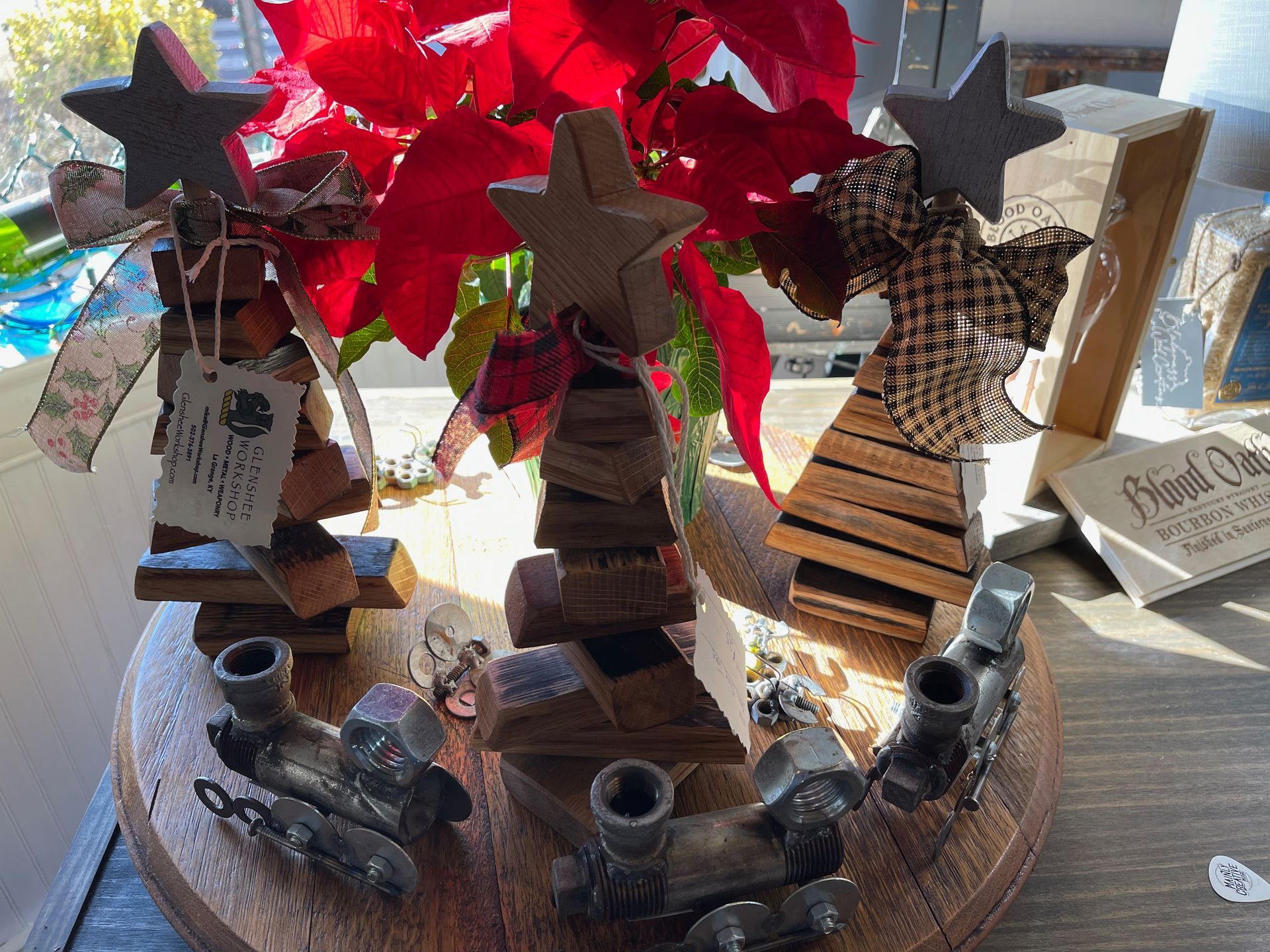 A wooden table topped with christmas decorations and a vase of flowers.