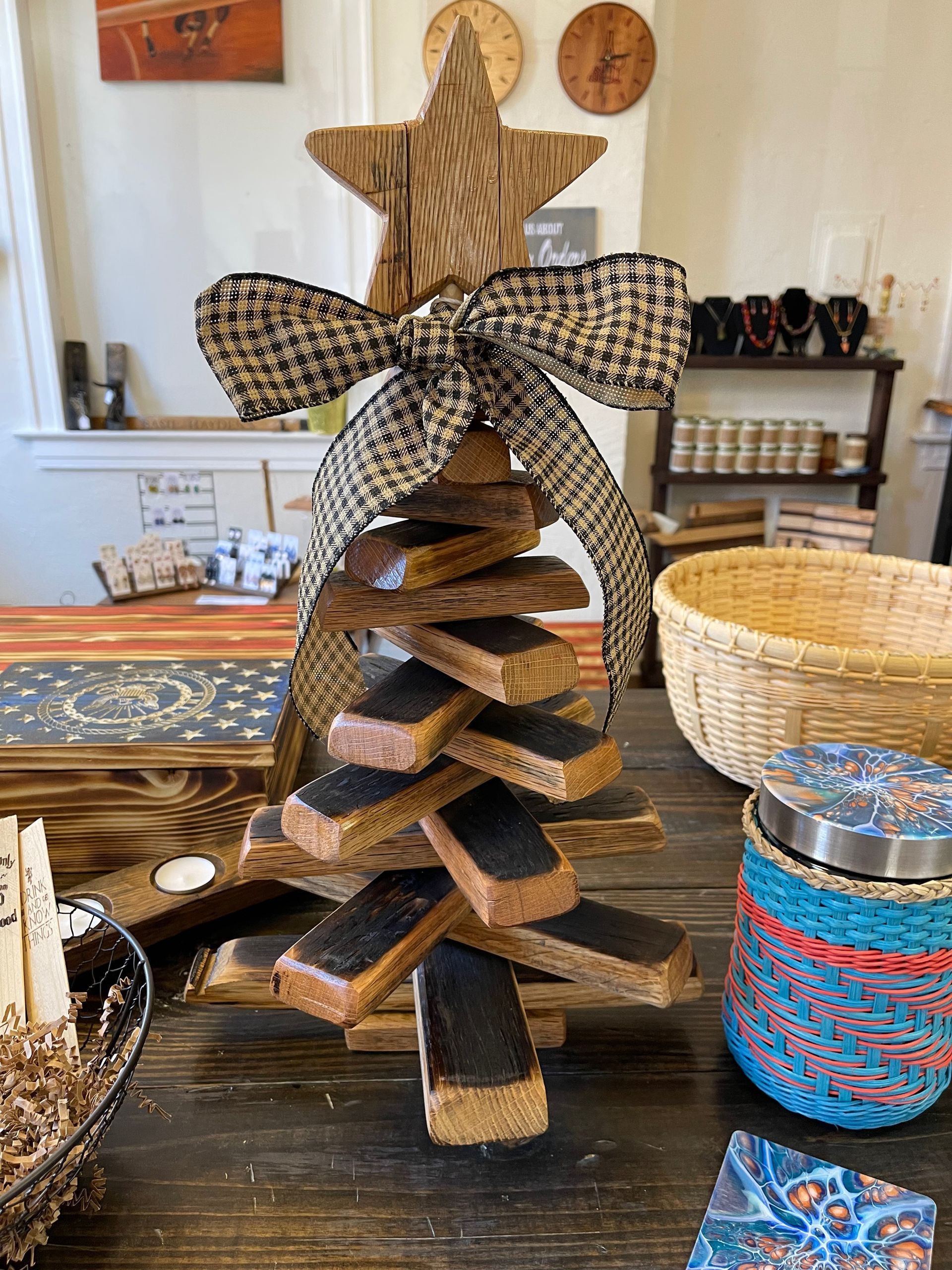 A wooden christmas tree with a star on top is sitting on a table.