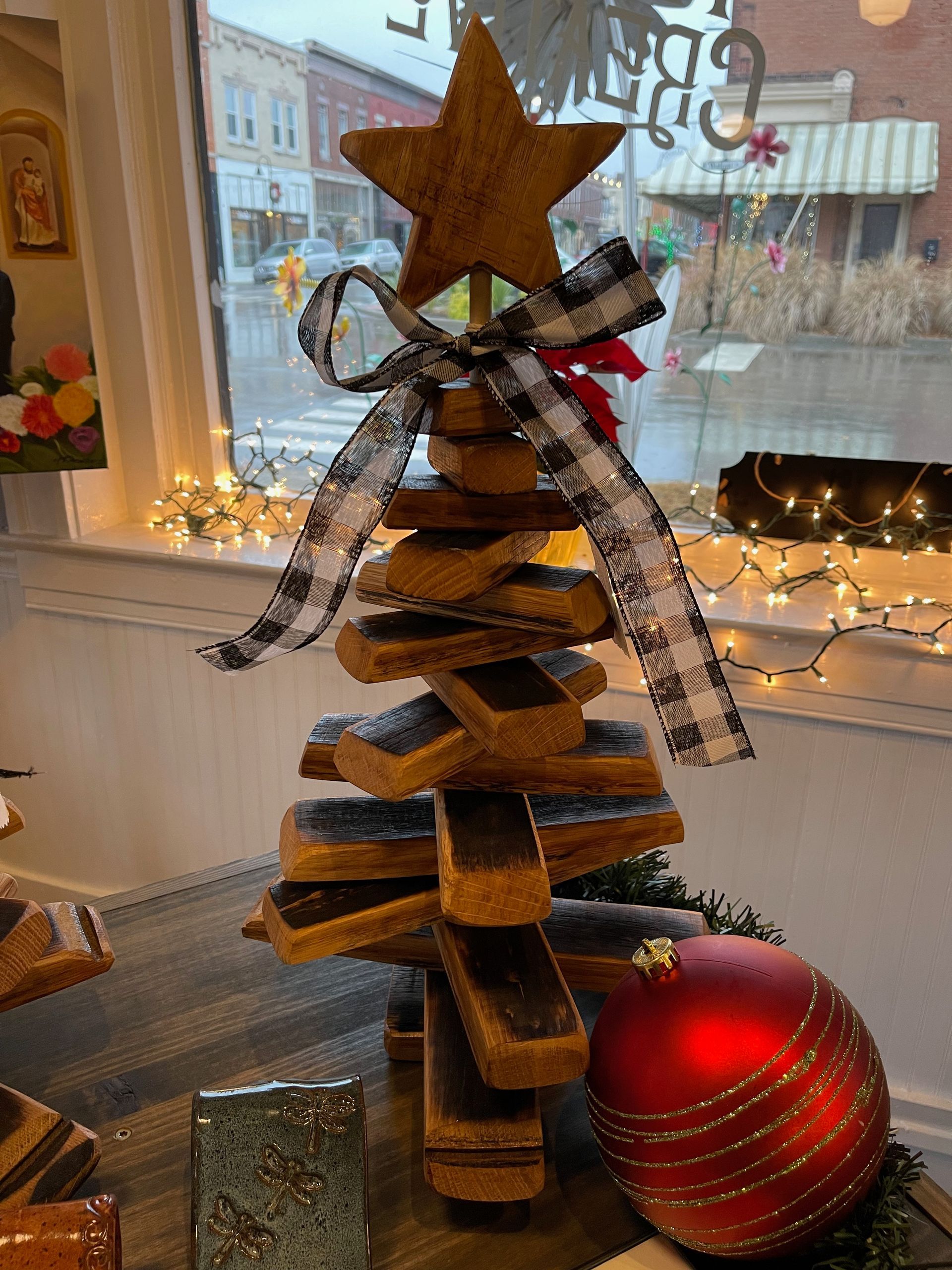 A wooden christmas tree with a star on top is sitting on a table.