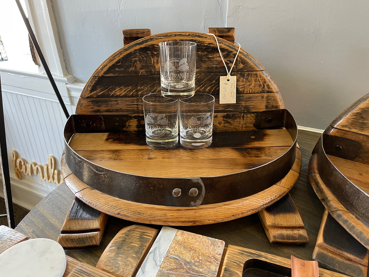 A wooden barrel with two glasses on top of it.