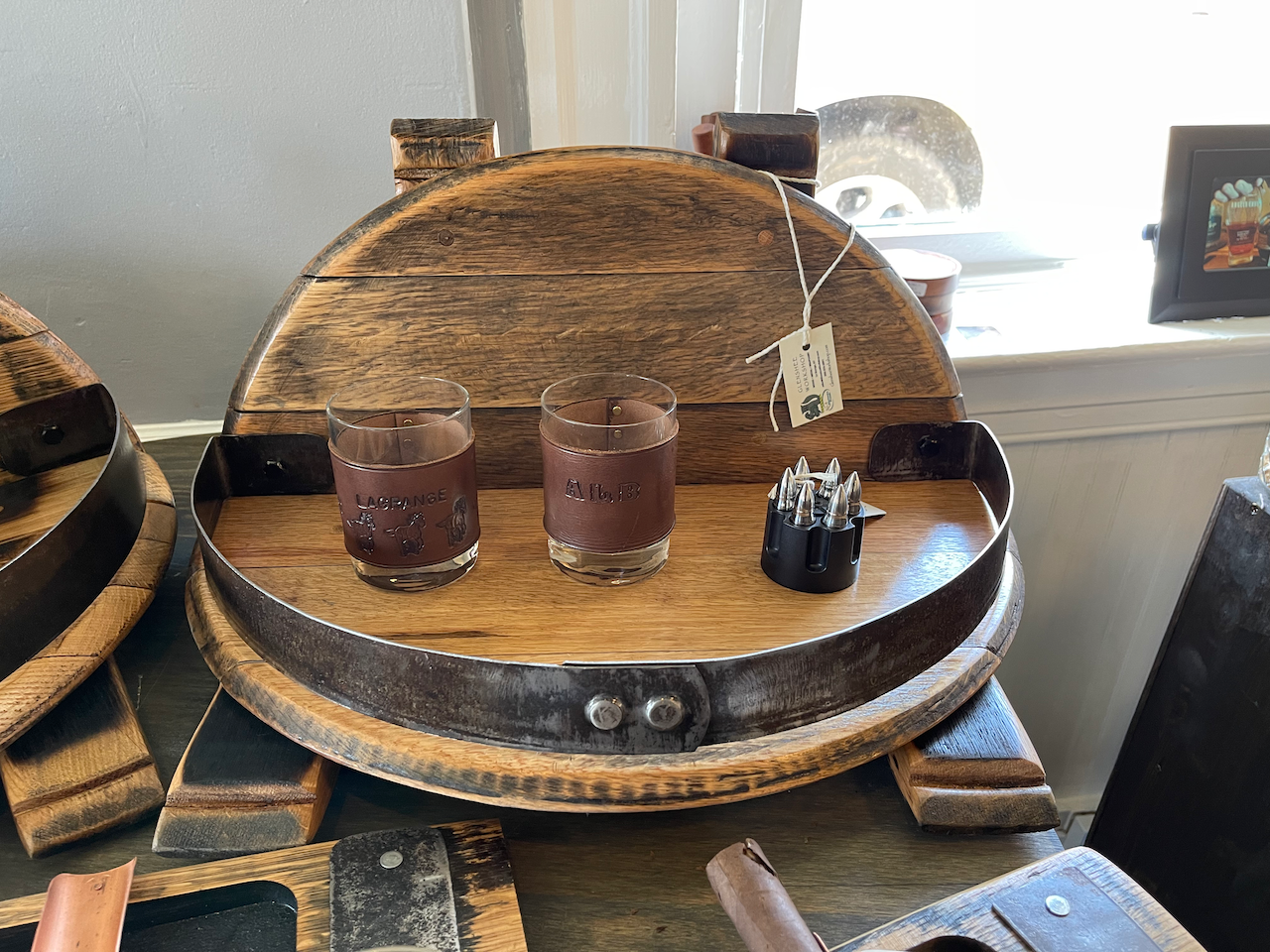 Two shot glasses are sitting on a wooden tray.