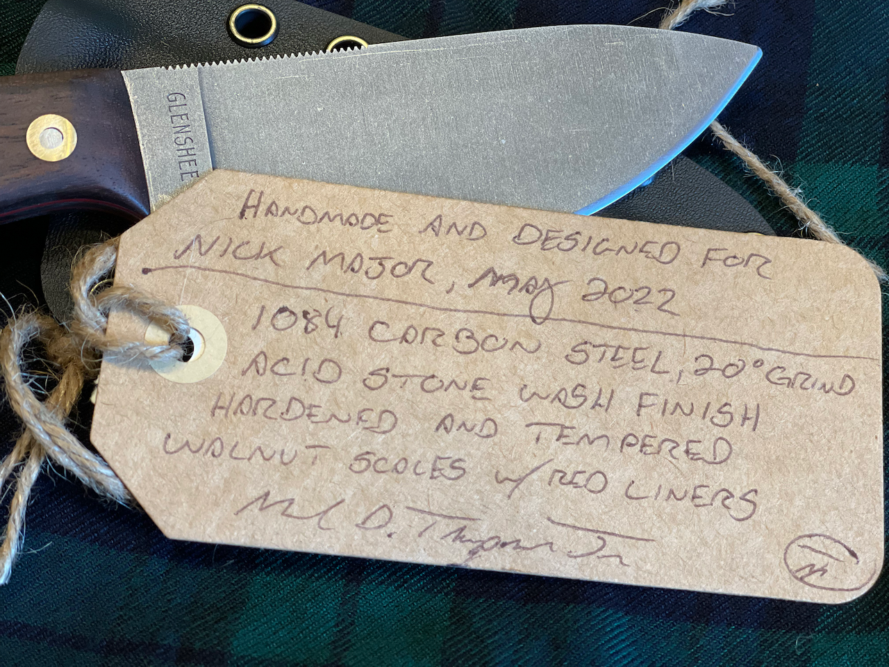A tag that says handmade and designed by nick mason