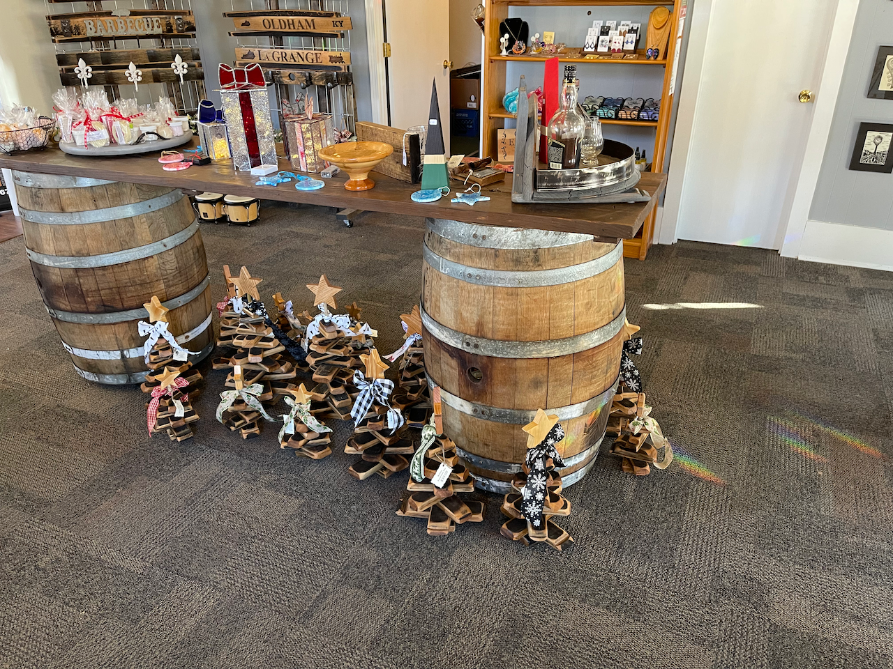 A room with wooden barrels and christmas trees on the floor.