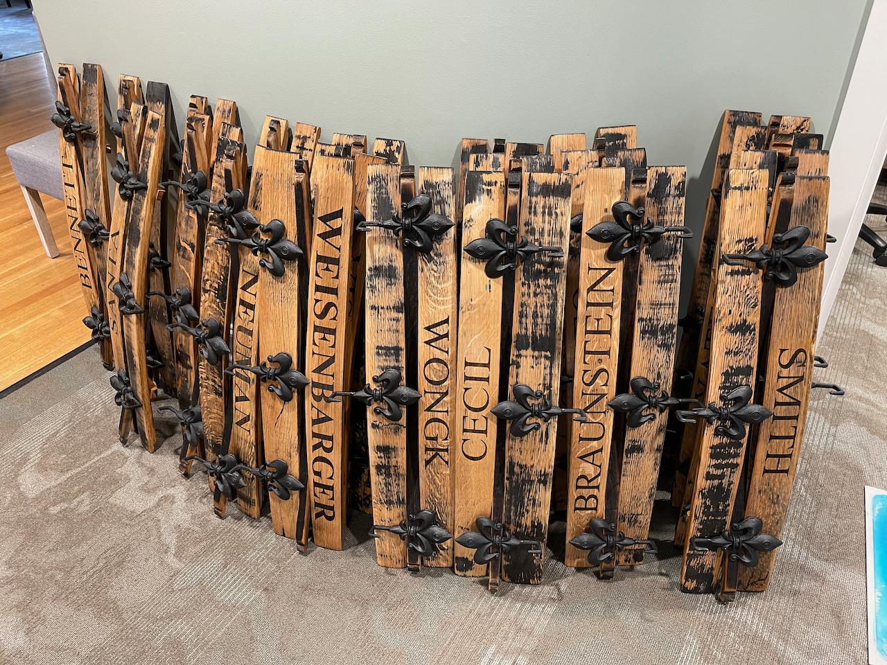 A wooden fence made out of wooden barrels is sitting on the floor.