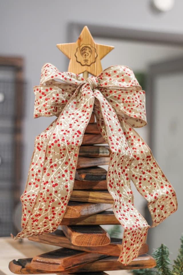 A wooden christmas tree with a bow and star on top of it.