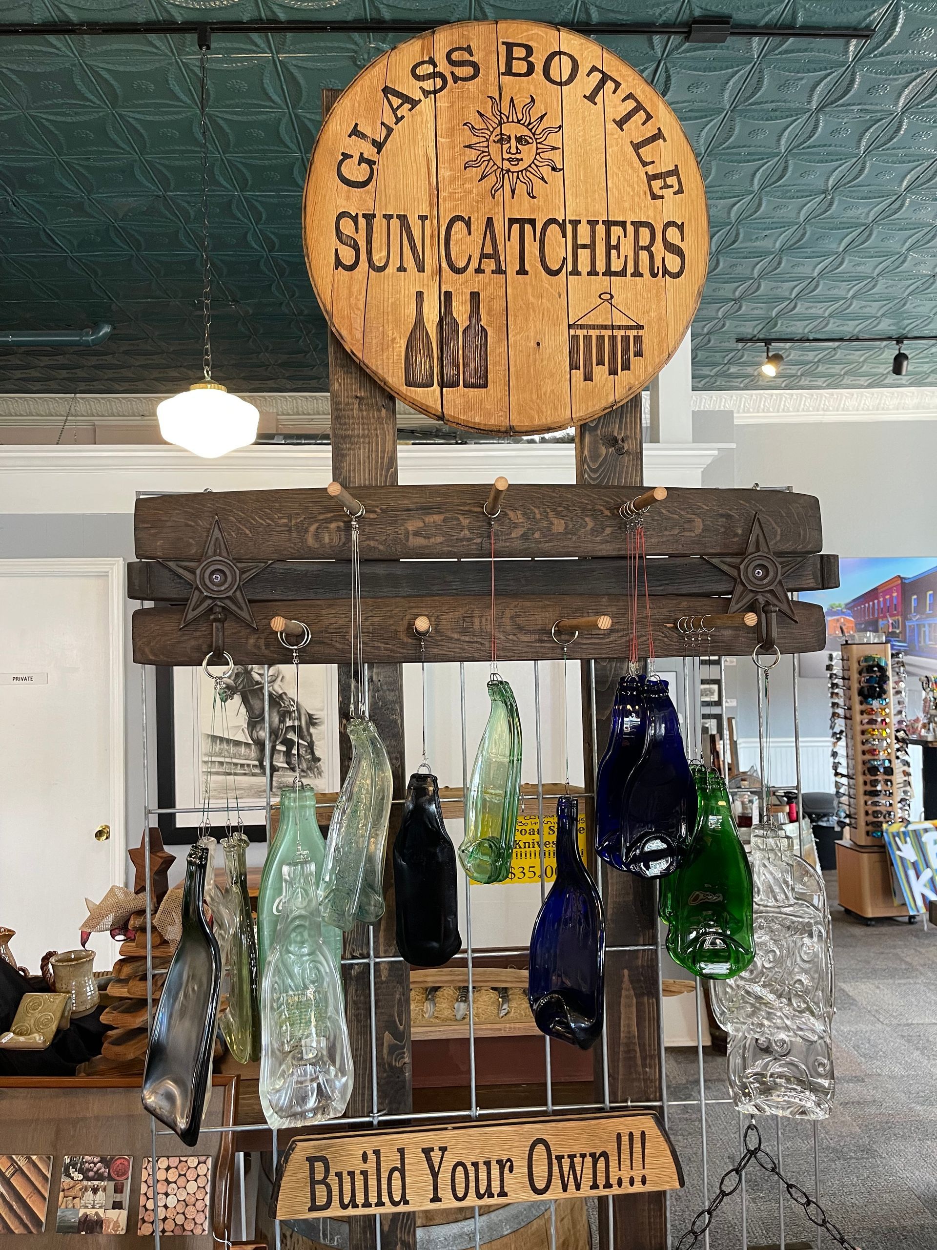 A wooden sign that says glass bottle suncatchers on it