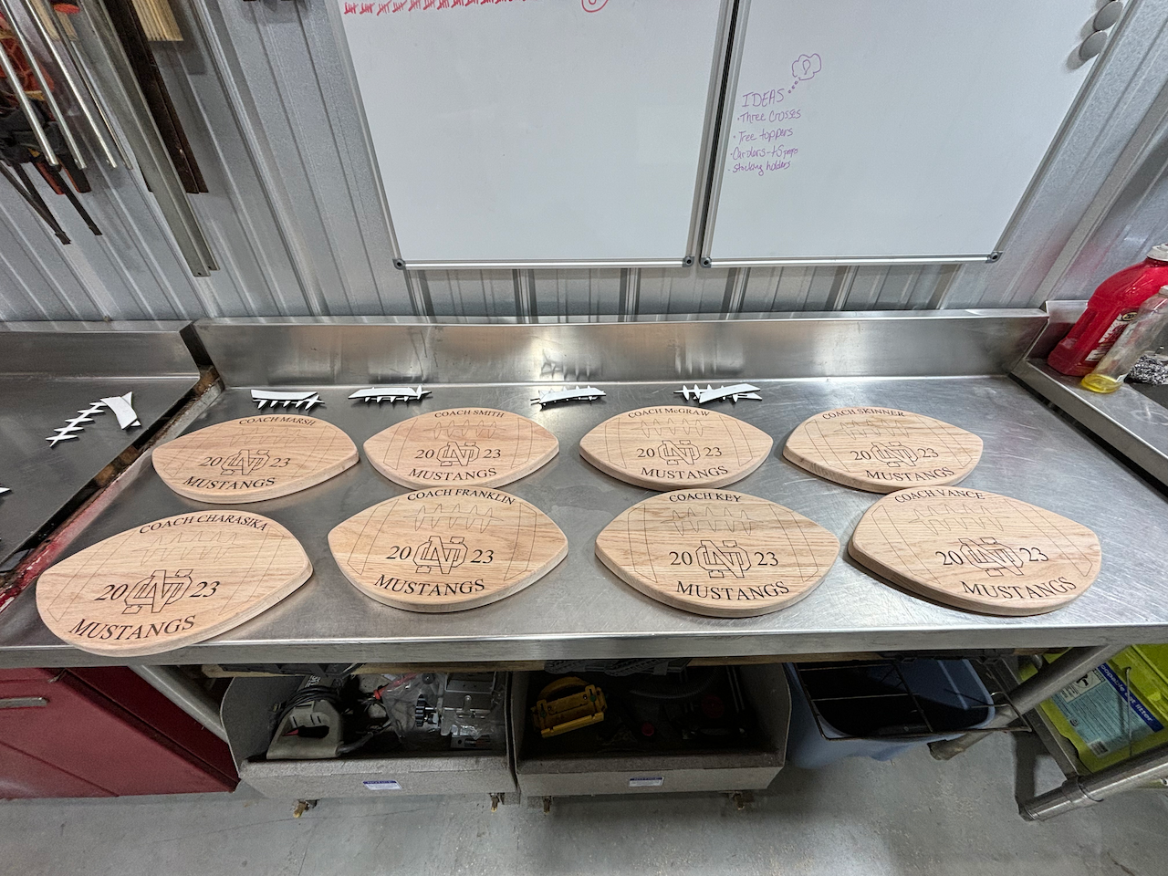A bunch of wooden plates are sitting on top of a stainless steel counter.