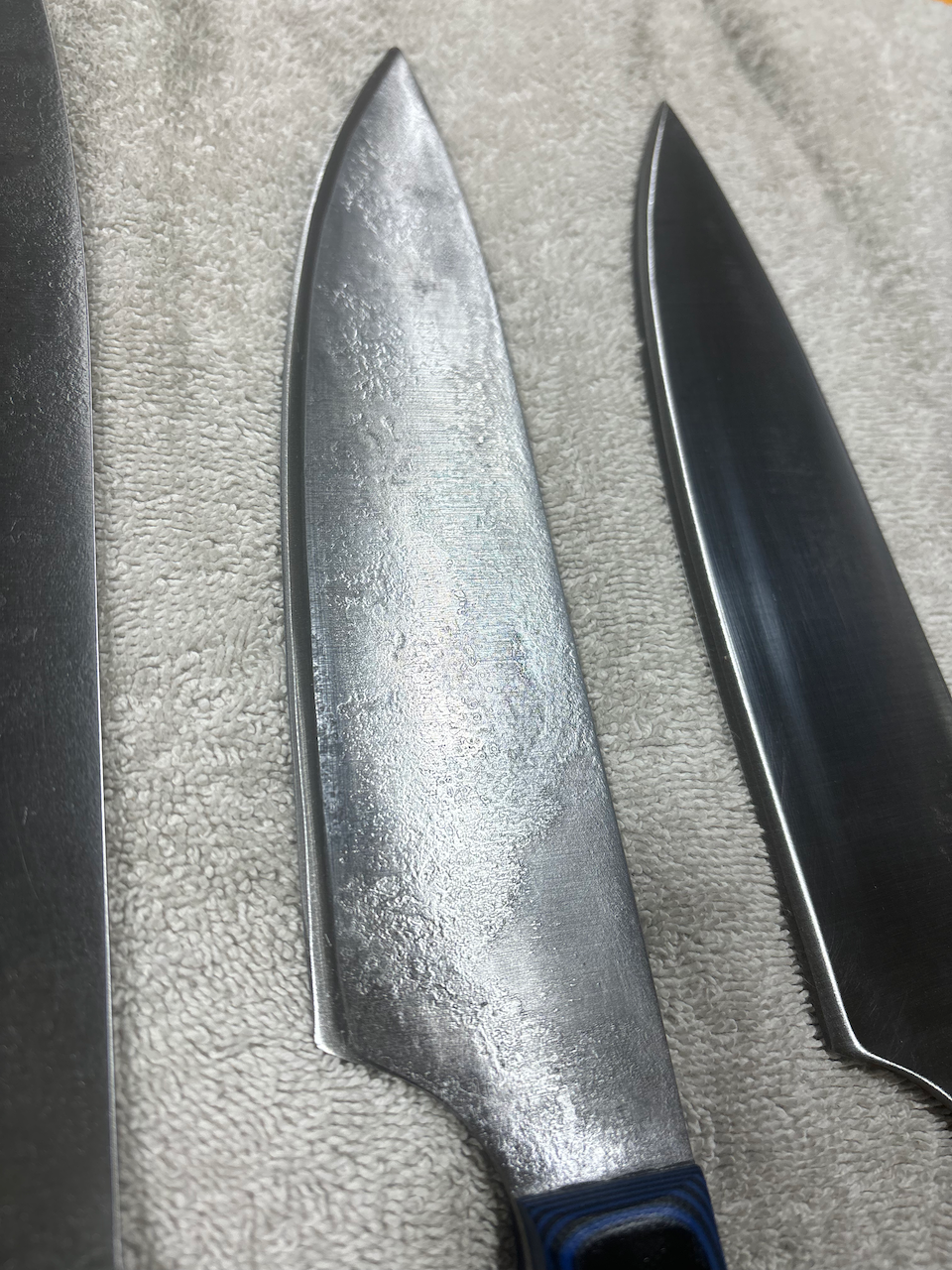 Two knives are sitting on a towel on a table.