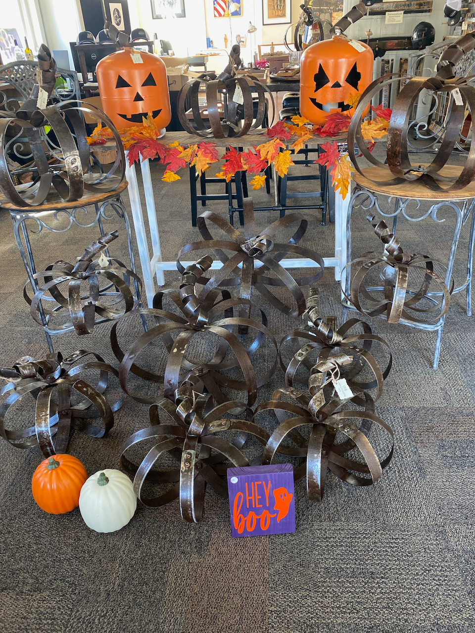 Two pumpkins are sitting on a table next to a sign that says trick or treat.