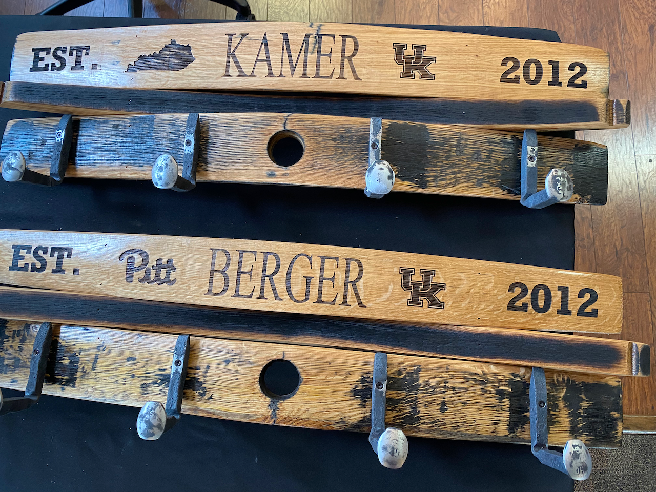A row of wooden hooks with the names kamer and pat berger written on them