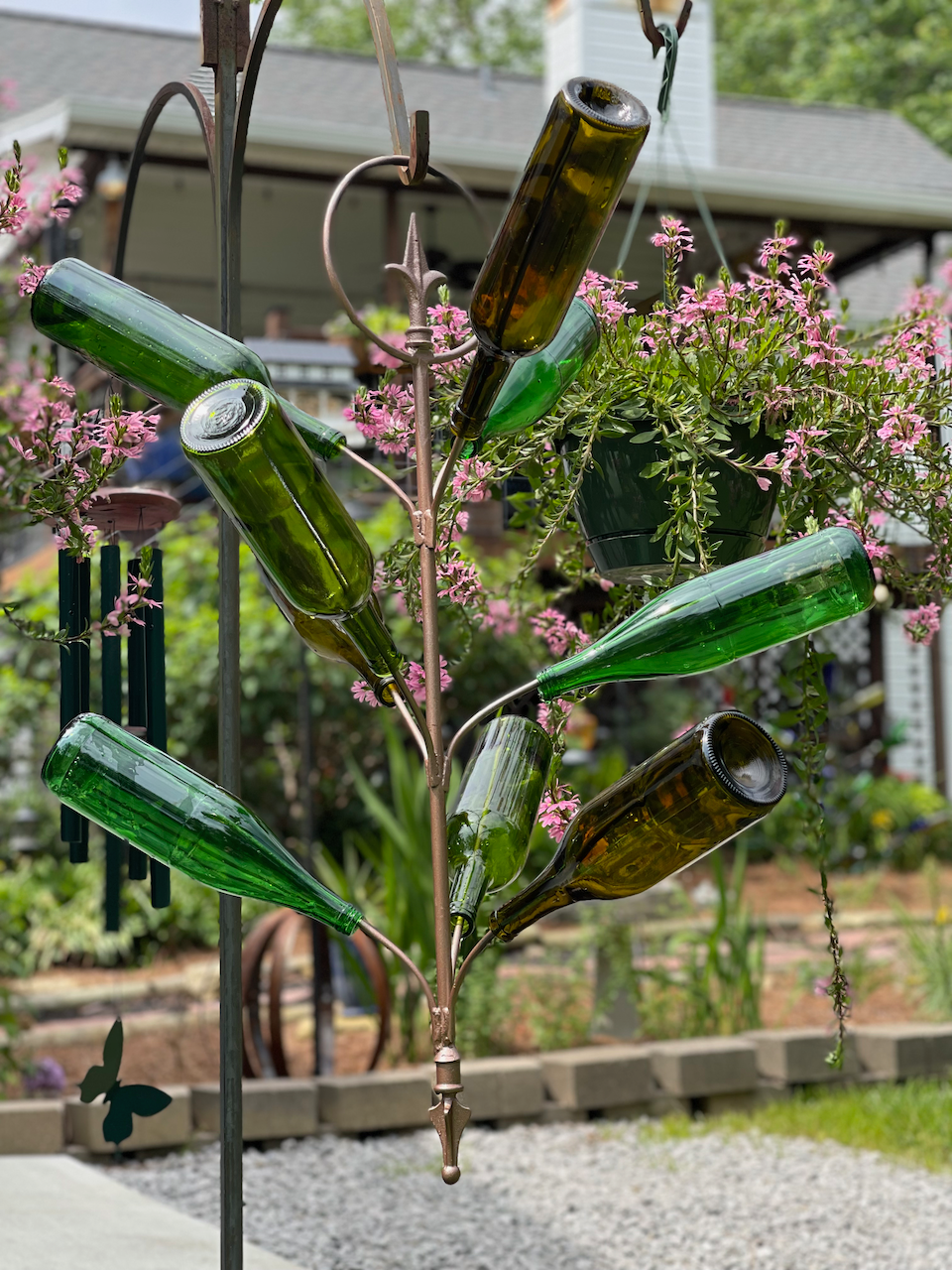 A tree made out of wine bottles in a garden.