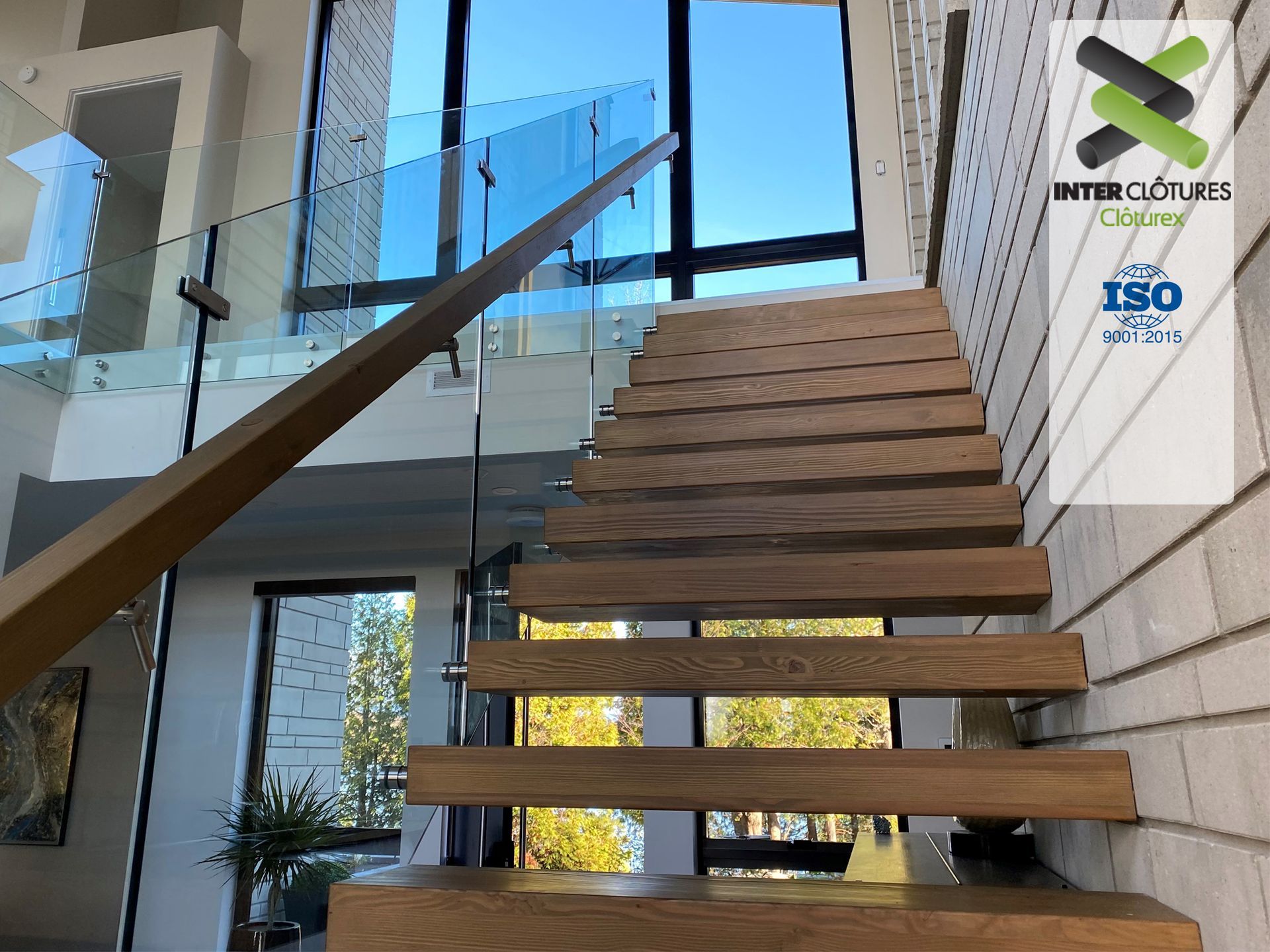 Un escalier en bois avec une rampe en verre dans une maison
