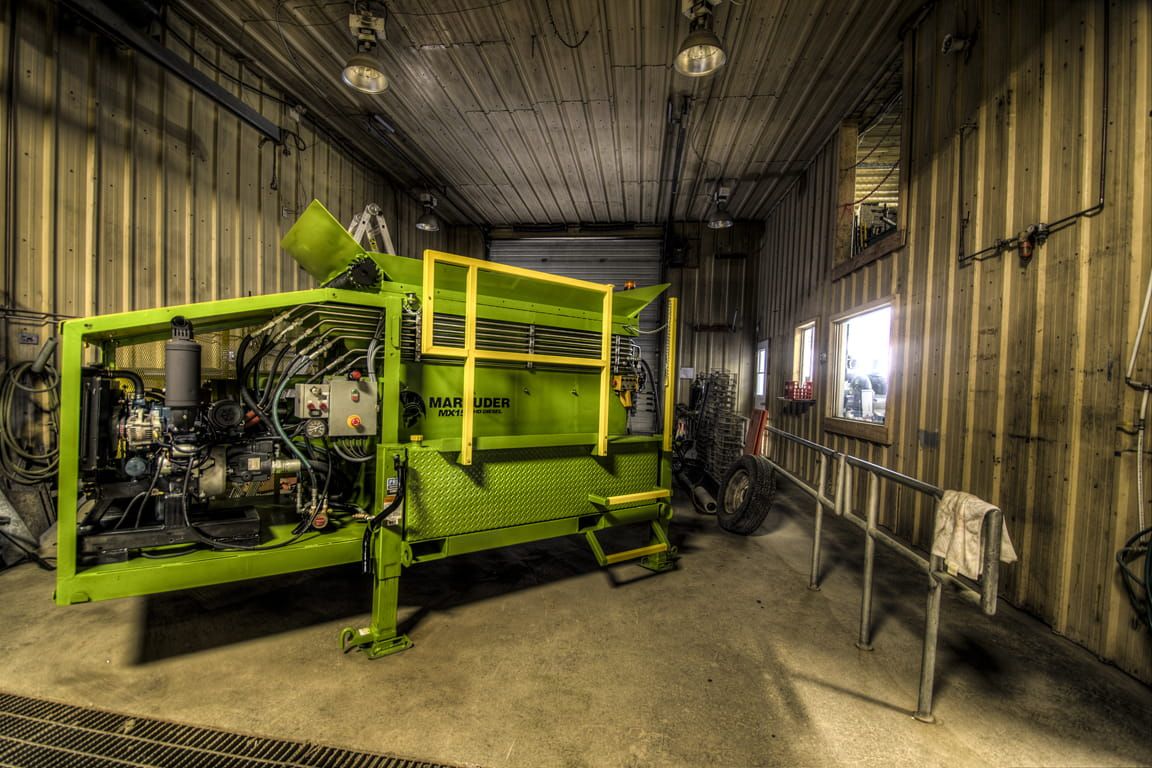 Une machine verte et jaune est assise dans un garage.
