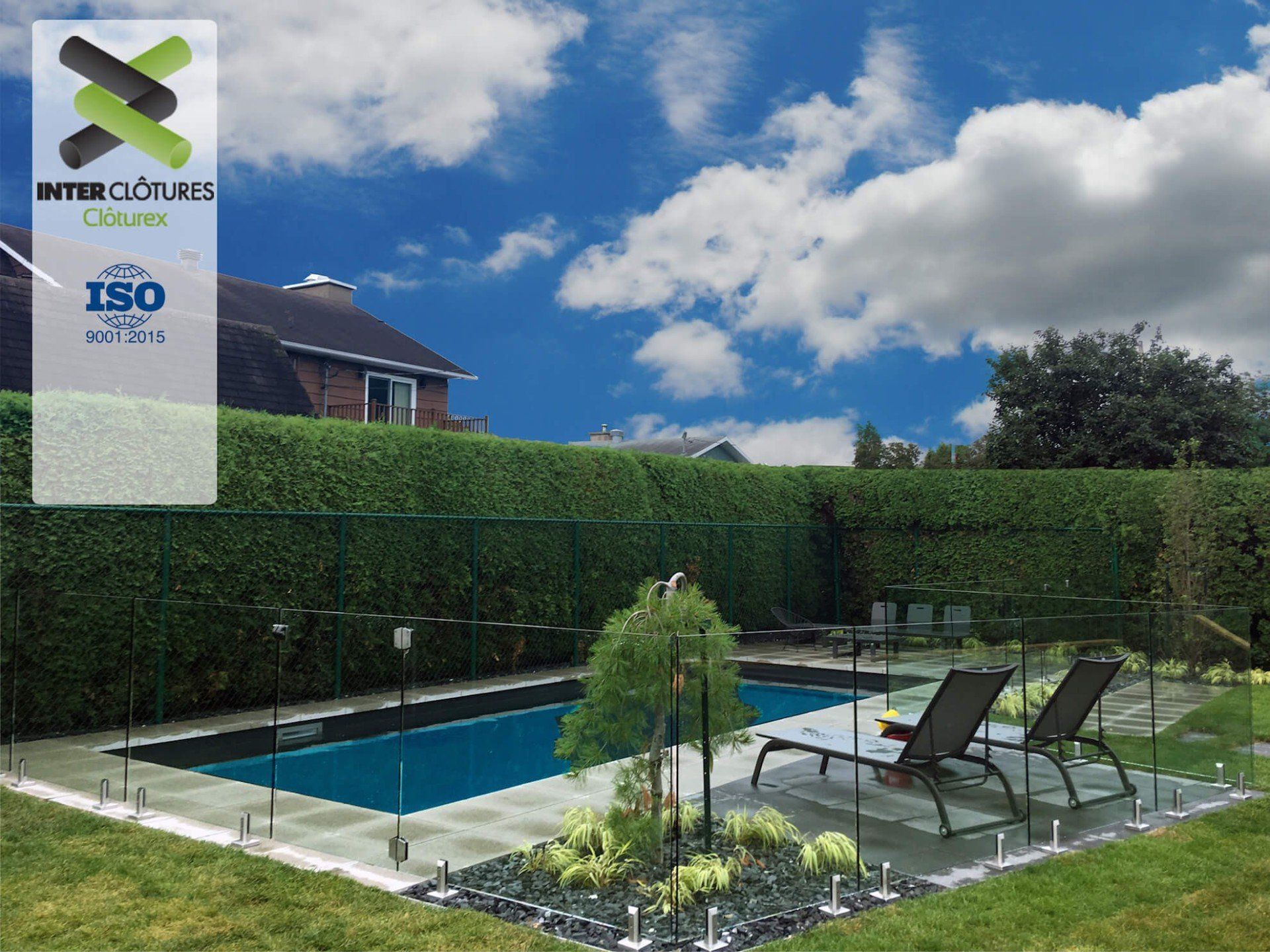 Une piscine est entourée d'une clôture en verre