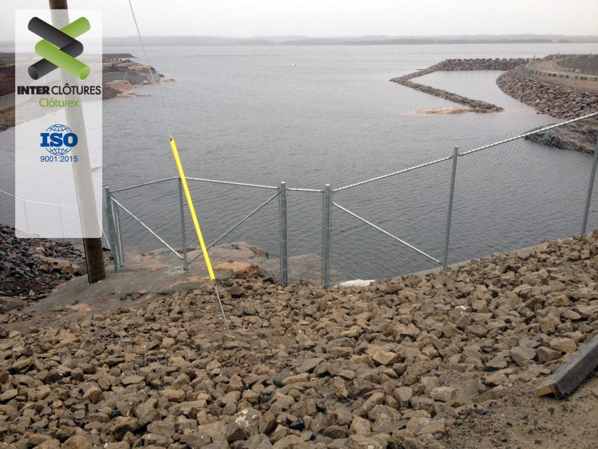 Une clôture entoure un plan d'eau avec un panneau indiquant ISO dessus