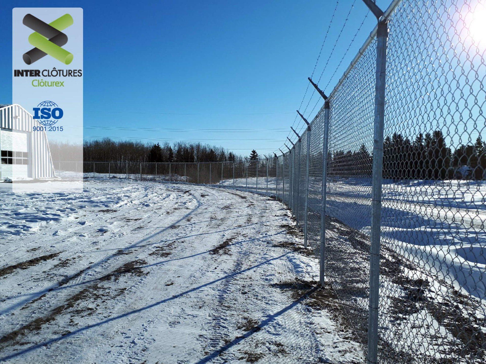 Une clôture grillagée entoure un champ couvert de neige