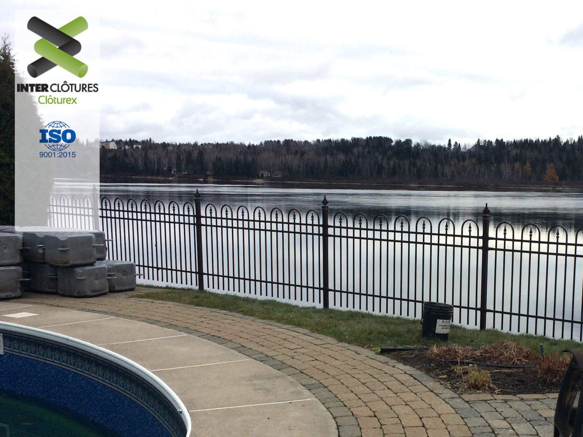 Une clôture métallique entoure un grand plan d'eau