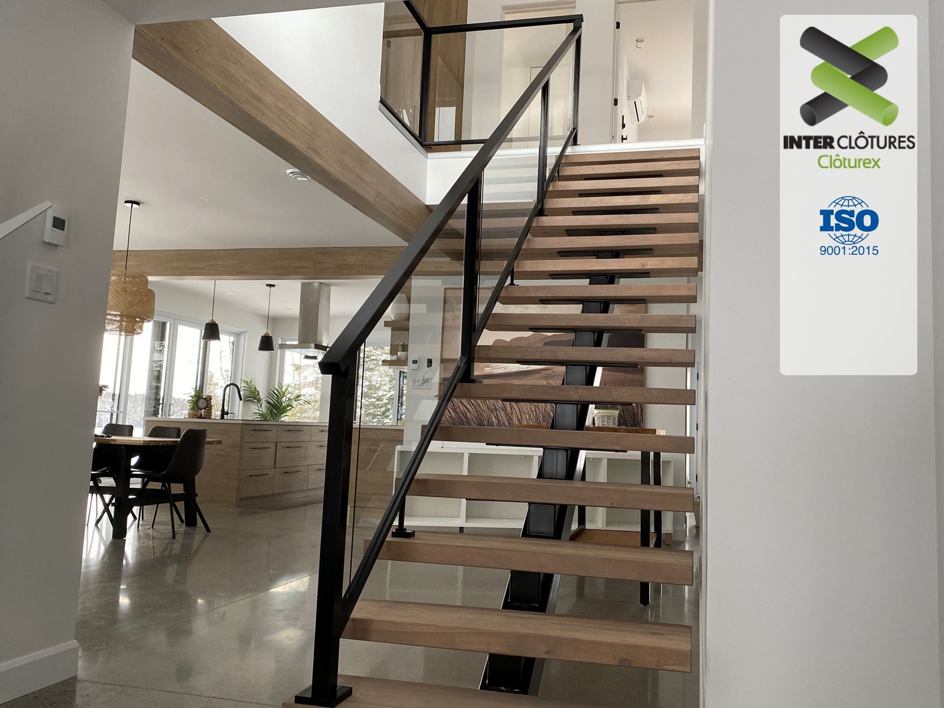 Un escalier en bois avec une rampe noire dans une maison