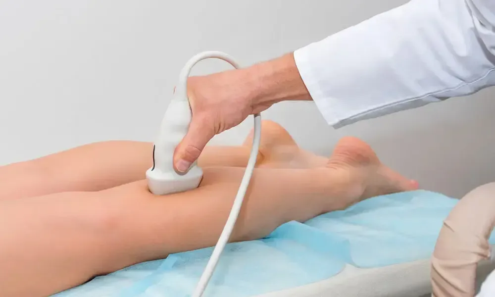 A doctor is using an ultrasound machine on a patient 's leg.