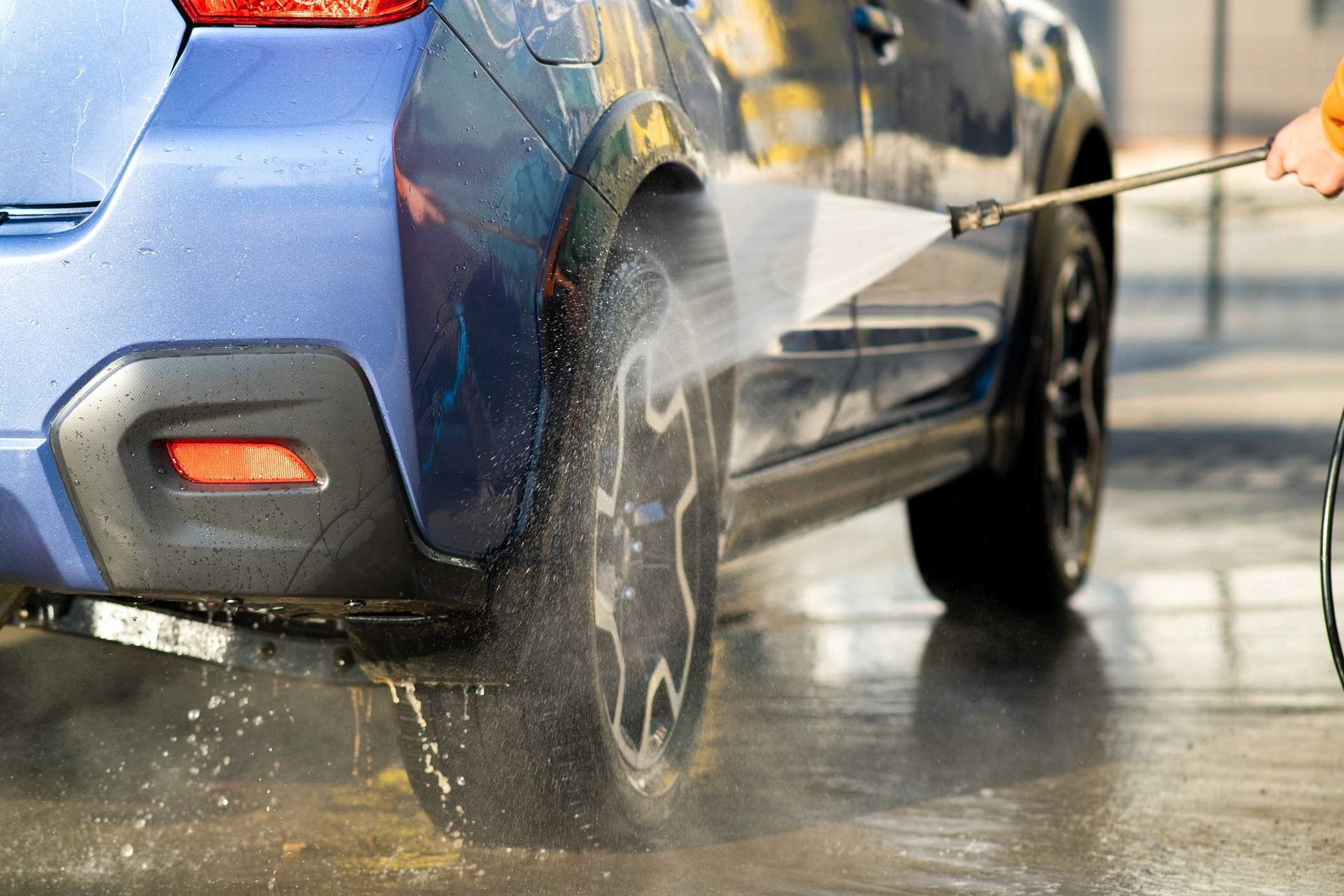 Driver washing his car with contactless high pressure water jet in self service car wash. Driver washing his car with contactless high pressure water jet in self service car wash.
