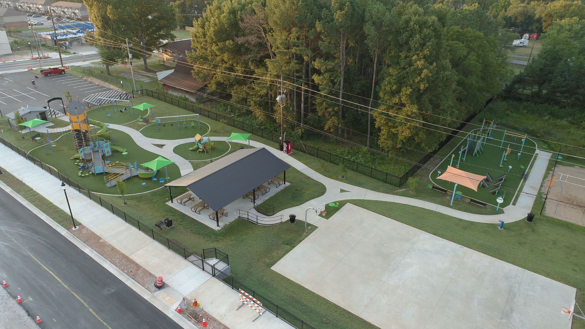 Aerial view of a park with a playground, pavilion, and walking paths.