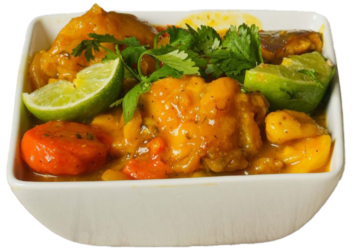 Bowl of yellow curry with chicken, tomatoes, and lime wedges, garnished with cilantro.