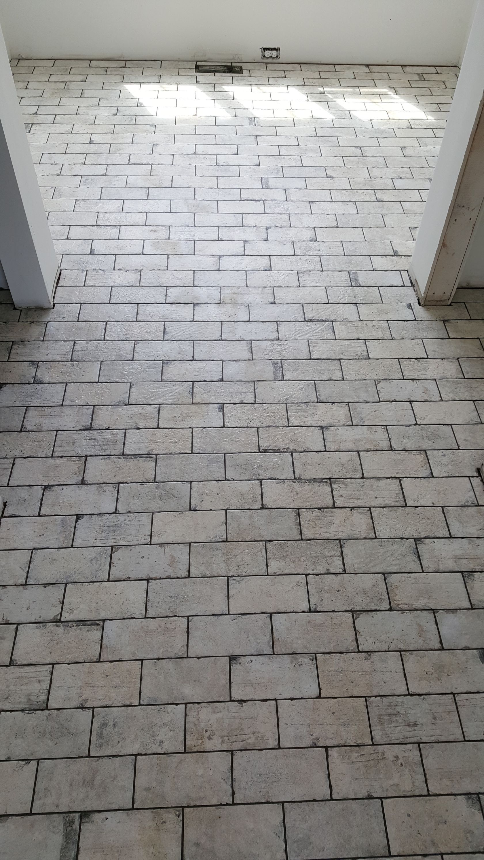 Brick wall with a passage, lit from above.