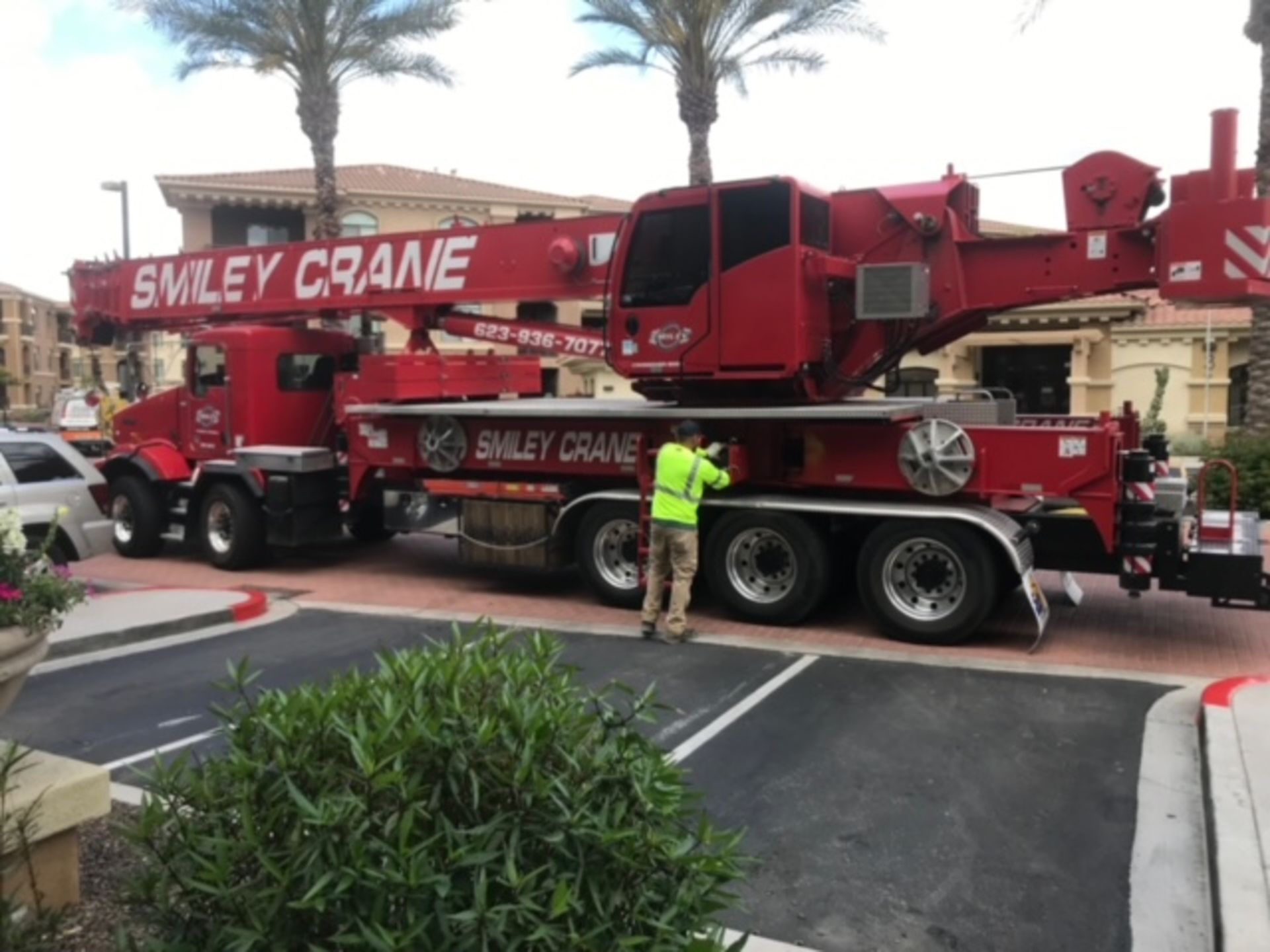A smiley crane truck is parked in a parking lot