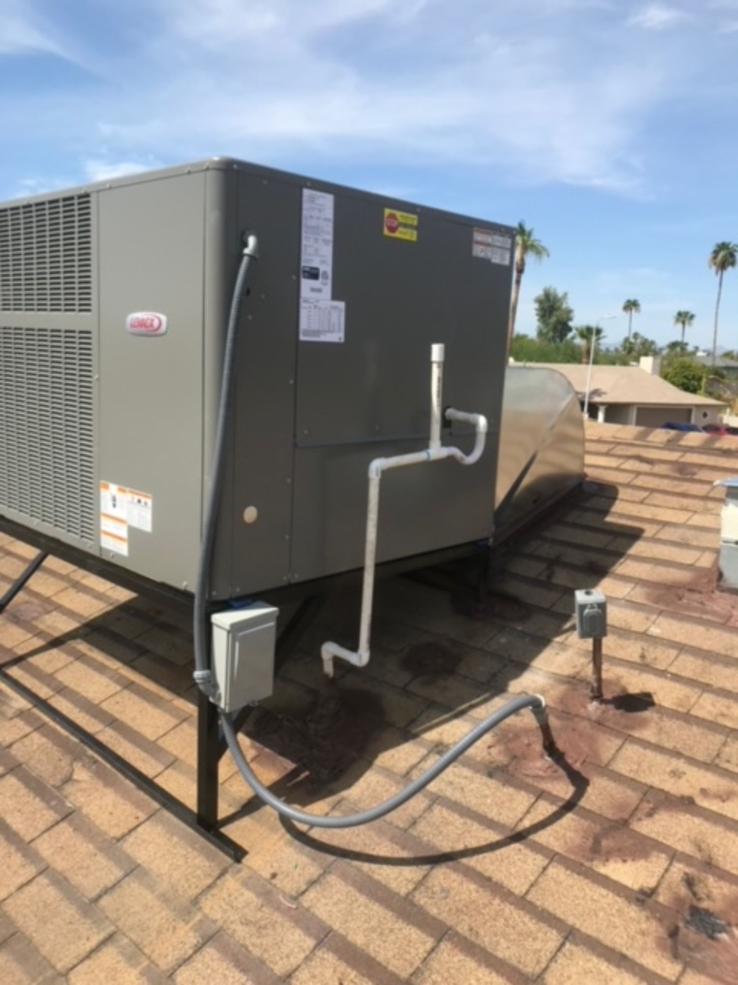 A large air conditioner is sitting on top of a roof.